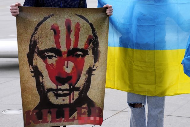 총선을 하루 앞둔 4월 2일 헝가리 수도 부다페스트에서 블라디미르 푸틴 러시아 대통령 얼굴에 붉은 손바닥 자국을 찍은 그림 팻말을
 들고 선 반전(反戰) 시위자. 그림 밑에 ‘살인자(killer)’라는 문구와 우크라이나 국기를 상징하는 ‘파랑-노랑’ 리본이 
보인다.