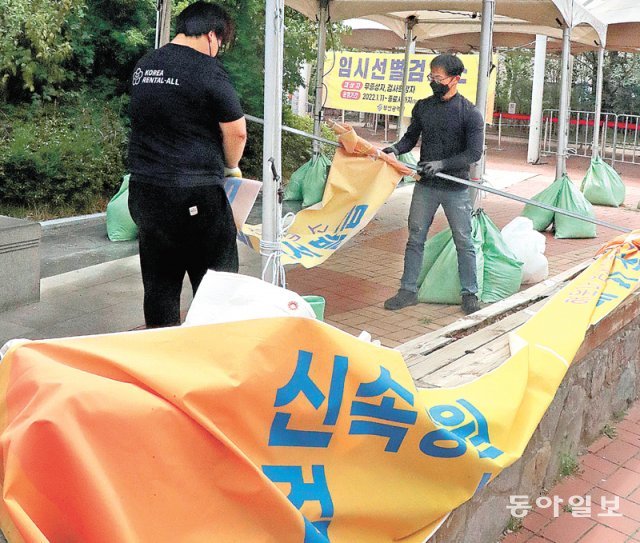 확진자 감소에 문 닫는 신속항원검사 시설 11일 부산 해운대구 복합문화센터 주차장에 설치된 임시선별검사소에서 
관계자들이 신속항원검사 시설을 철거하고 있다. 이날부터 전국의 선별진료소와 임시선별검사소에서 코로나19 신속항원검사가 중단됐다. 
오미크론 변이 대유행 감소세에 따른 조치다. 전국 임시선별검사소 202곳 중 4곳은 이날부터 운영을 중단했다. 60세 이상은 
종전과 마찬가지로 선별진료소에서 유전자증폭(PCR) 검사를 받을 수 있다. 부산=박경모 기자 momo@donga.com