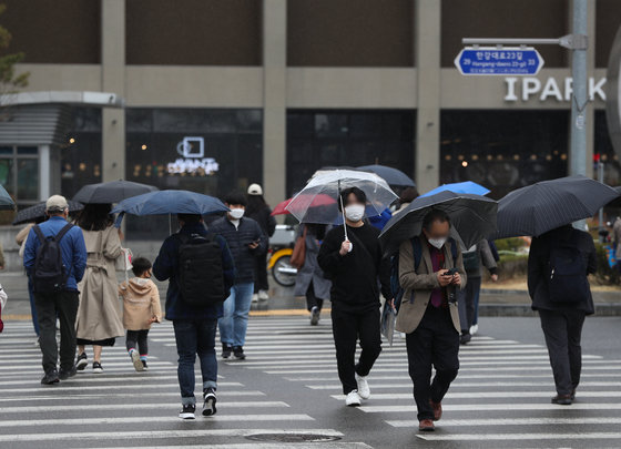 3월30일 오후 서울 용산역 광장에서 어머니가 아들이 직접 우산을 들 수 있도록 도와주고 있다. 2022.3.30/뉴스1 © News1