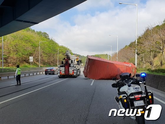 12일 오전 전남 광양의 한 고가도로에서 컨테이너 차량 일부가 아래도로로 추락해 구조 당국이 수습하고 있다. 광양소방서 제공/뉴스1