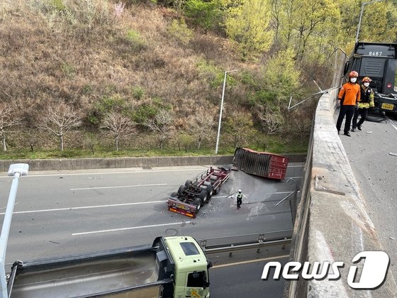 12일 오전 전남 광양의 한 고가도로에서 컨테이너 차량 일부가 아래도로로 추락해 구조 당국이 수습하고 있다. 광양소방서 제공/뉴스1