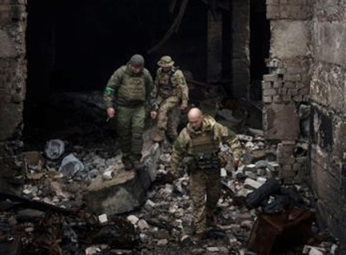 12일(현지시간) 우크라이나 하르키우 외곽에서 우크라이나 군인들이 앞서 러시아군이 임시 기지로 사용했던 건물 내부를 살피며 걷고 있다. 하르키우=AP/뉴시스