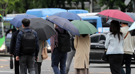 산발적인 이슬비가 내리는 17일 오전 서울 광화문네거리에서 우산 쓴 시민들이 출근길 발걸음을 재촉하고 있다. 2021.5.17/뉴스1
