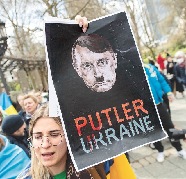 10일 독일 프랑크푸르트에서 열린 러시아의 우크라이나 침공 반대 시위에서 한 참가자가 블라디미르 푸틴 러시아 대통령과 아돌프 히틀러의 얼굴을 합성한 그림 포스터를 들고 있다. 프랑크푸르트=AP 뉴시스