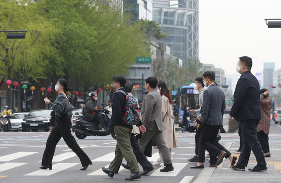 신종 코로나바이러스 감염증(코로나19) 확산을 막기위해 2년여 전 시행했던 사회적 거리두기가 해제된 18일 서울 종로구 광화문 네거리에서 마스크를 쓴 시민들이 출근을 하고 있다.  2022.4.18/뉴스1