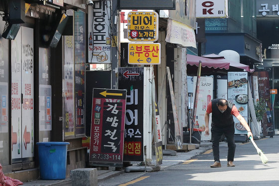 17일 서울 종로구 먹자골목에서 한 업주가 가게 앞을 청소하고 있다. 2022.4.17/뉴스1 © News1