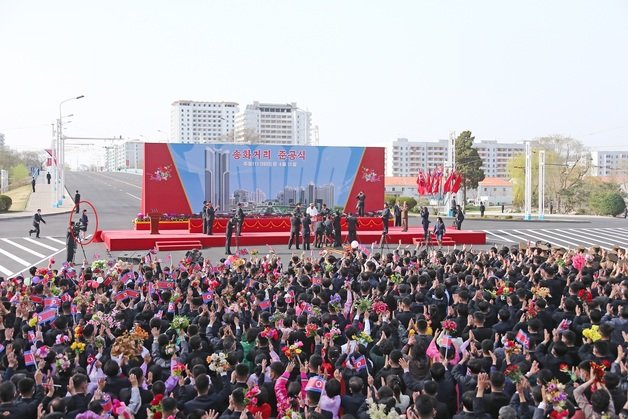 지난 11일 열린 북한 평양 송화거리 1만세대 살림집 준공식. 김정은 총비서의 ‘새 수행원(왼쪽 붉은 원 안)’의 모습도 포착됐다. (평양 노동신문=뉴스1)