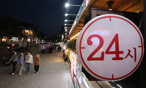 사회적 거리두기가 해제된 18일 저녁 서울 홍대거리의 한 음식점 입구에 24시간 영업을 알리는 간판에 불이 켜져있다. 2022.4.18 뉴스1
