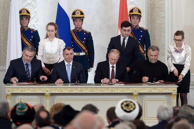 2014년 3월 18일 러시아 수도 모스크바에서 푸틴(오른쪽에서 5번째)이 크름 자치공화국 지도자들과 함께 크름반도의 러시아 합병을 승인하는 조약에 서명하고 있다. 크렘린궁 홈페이지