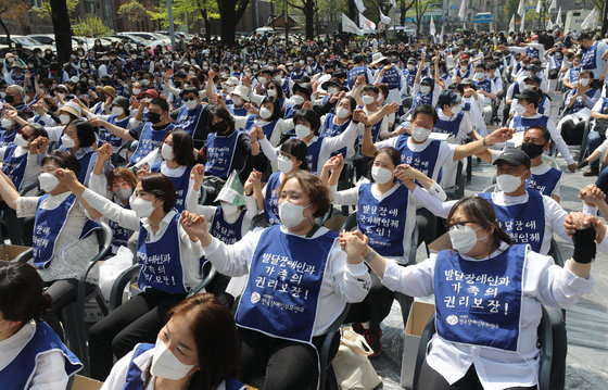 19일 오후 서울 종로구 청와대 인근에서 전국장애인부모연대 주최로 열린 ‘발달장애인 24시간 지원 체계 구축을 위한 1박 2일 집중 결의대회’에서 참석자들이 손을 맞잡고 있다. 2022.4.19/뉴스1 © News1