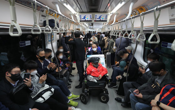 전국장애인차별철폐연대(전장연) 회원들이 21일 오전 서울 경복궁역 3호선 열차에서 장애인권리예산 확보 및 장애인 이동권 보장 촉구 시위를 하고 있다. 전장연은 ‘장애인권리예산 보장’과 ‘장애인 민생 4대 법안’의 구체적 실행 방안이 부실하다고 판단해 이날 오전 7시부터 ‘출근길 지하철 타기’ 시위를 재개했다. 2022.4.21/뉴스1 © News1