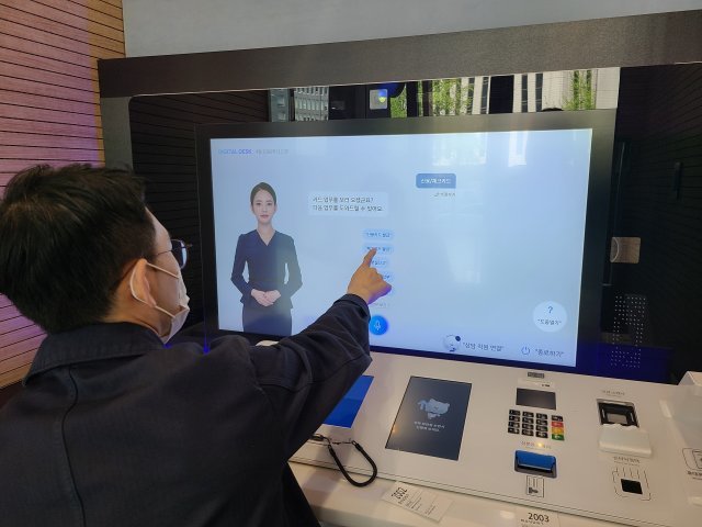 19일 신한은행 서울 서소문지점에서 기자가 직접 인공지능 은행원의 서비스를 체험하고 있다.