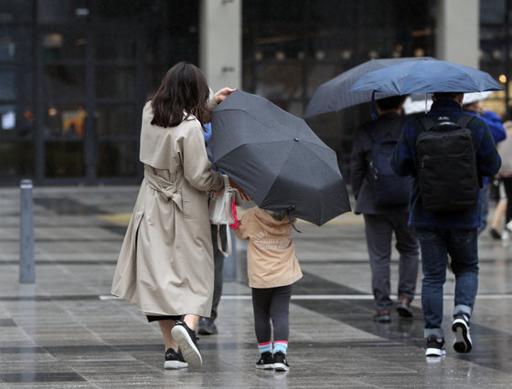 봄을 재촉하는 비가 내린 30일 오후 서울 용산역 광장에서 어머니와 아들이 비를 피하고 있다. 2022.3.30/뉴스1