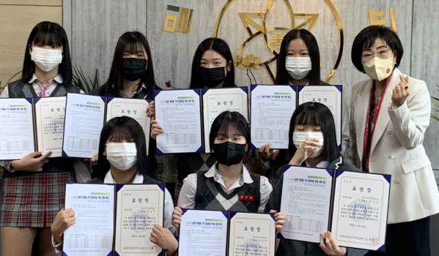 26일 경남 밀양교육지원청의 표창을 받은 밀양여중 학생 7명과 김정희 교육장(오른쪽)이 포즈를 취하고 있다. 경남 밀양교육지원청 제공