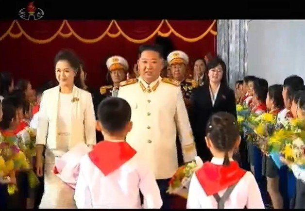 김정은 북한 국무위원장이 주석단에서 화동의 꽃을 받을 때 의문의 여성(오른쪽)이 수행을 하고 있다. (조선중앙TV 갈무리) 뉴스1
