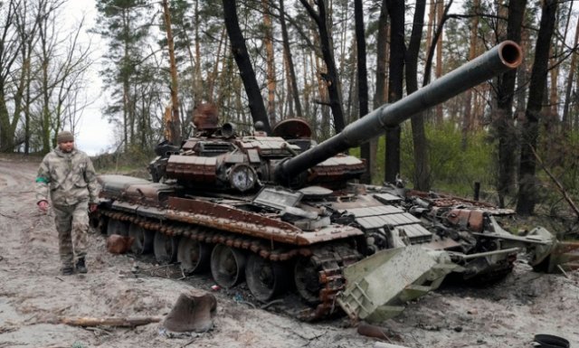 19일(현지시간) 한 우크라이나 군인이 키이우 인근 지역에서 전투 후 버려진 러시아군 탱크 옆을 지나고 있다. 2022.04.19 키이우=AP/뉴시스