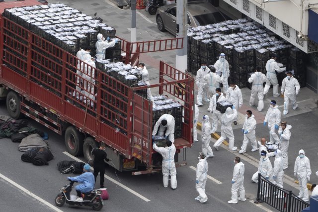 6일 중국 상하이에서 보호복을 착용한 작업자들이 주민들에게 나눠줄 식료품 등을 트럭에서 내리고 있다. 코로나19 급증으로 봉쇄 중인 상하이는 사실상 무기한 전면 봉쇄에 들어갔다. 2022.04.06. 상하이=AP/뉴시스