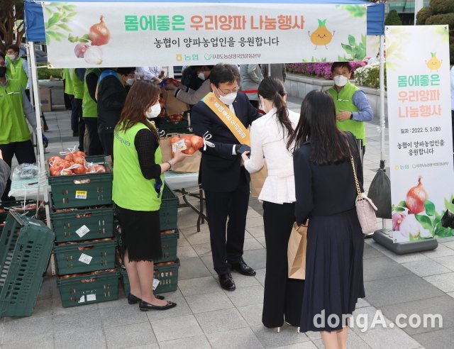 이재식 농협중앙회 부회장이 3일 오후 서울 중구 농협중앙회 본관 광장에서 개최된 양파 소비촉진 나눔행사에서 농협을 방문하는 고객과 임직원을 대상으로 햇양파 1망씩 증정하고 있다. 농협 제공