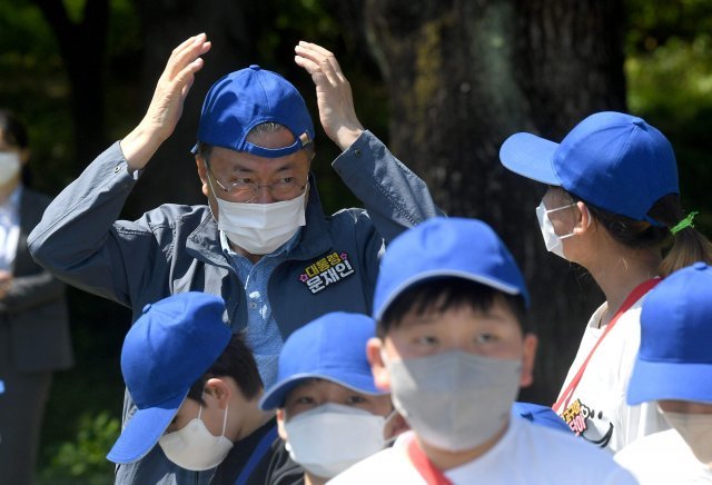 문재인 대통령이 5일 청와대 녹지원에서 열린 ‘2022년 어린이날 100주년 기념 청와대 어린이 초청행사’에서 모자를 뒤집어 쓰고 있다. 청와대사진기자단