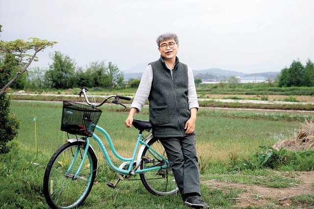 전남 곡성군의 들녘에서 자전거와 함께 서 있는 소설가 김탁환. 그는 “오전 집필을 마친 뒤엔 산, 들, 강 어디로도 갈 수 
있다”며 “자전거를 타고 가거나 걷다가 조금만 호기심을 따르면 낯선 풍경과 만난다”고 했다. 권영일 사진가 제공