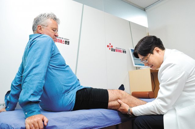 퇴행성관절염진단후 줄기세포 수술을 받은 거스 히딩크 감독(왼쪽)의 무릎을 송준섭 박사가 진료 보고 있다. 강남제이에스병원 제공