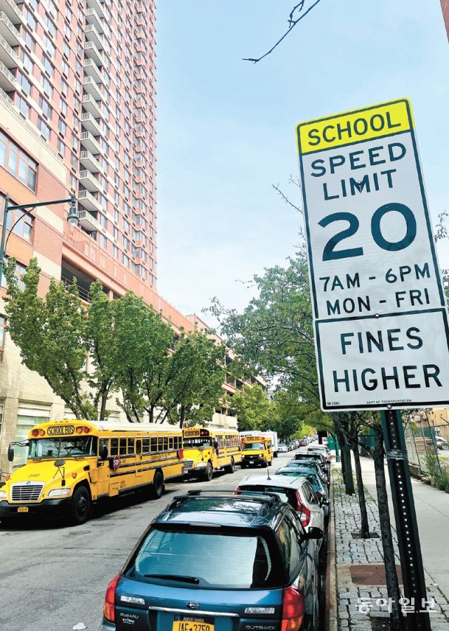 미국 뉴욕시의 한 공립학교 앞에 하교 시간에 맞춰 스쿨버스 여러 대가 서 있다. 버스 옆으로는 제한속도 시속 20마일(약 32km)과 ‘스쿨존’을 뜻하는 표지판이 보인다. 뉴욕=유재동 특파원 jarrett@donga.com