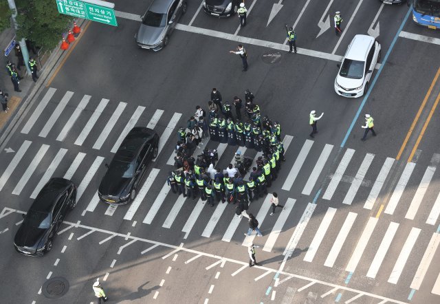 17일 오전 서울 용산구 신용산역 인근에서 출근길 행진을 하는 전국장애인자별철폐연대(전장연) 회원들이 경찰에 둘러싸여 있다. 뉴시스