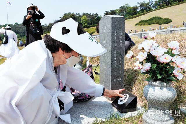 5·18민주화운동 제42주년 기념일인 18일 광주 북구 운정동 국립5·18민주묘지에서 기념식이 끝난 뒤 묘역을 찾은 한 유가족이 묘비를 어루만지며 슬퍼하고 있다. 박영철  기자  skyblue@donga.com