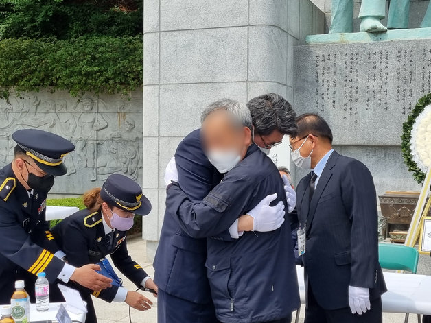 19일 오전 국립서울현충원 경찰충혼탑 앞에서 배모씨와 유족 대표 정원영(54)씨가 서로 끌어 안고 있다.© 뉴스1