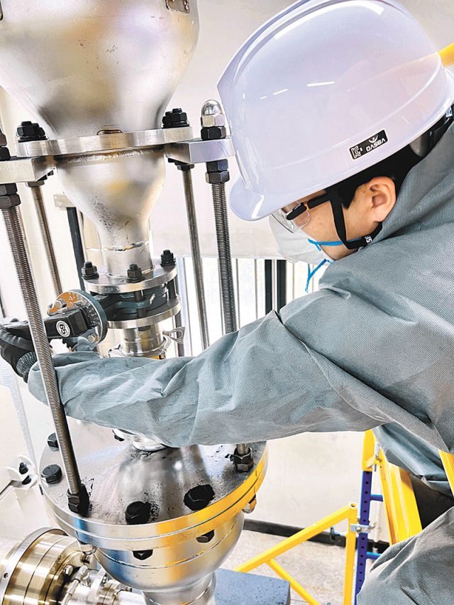 GS 챌린지를 통해 선발된 스타트업 에코알앤에스 임진호 과장이 폐배터리에서 나온 블랙파우더를 자체 개발한 리튬 추출 설비에 투입하고 있다. 에코알앤에스 제공