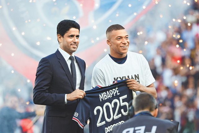 소속 팀 파리 생제르맹(PSG)과의 계약을 3년 연장한 킬리안 음바페(오른쪽)가 22일 프랑스 파리에서 열린 메츠와의 경기에 앞서
 나세르 알 켈라이피 PSG 회장과 함께 2025년까지  계약 연장을 의미하는 유니폼을 들고 함께 서 있다. 파리=신화 뉴시스