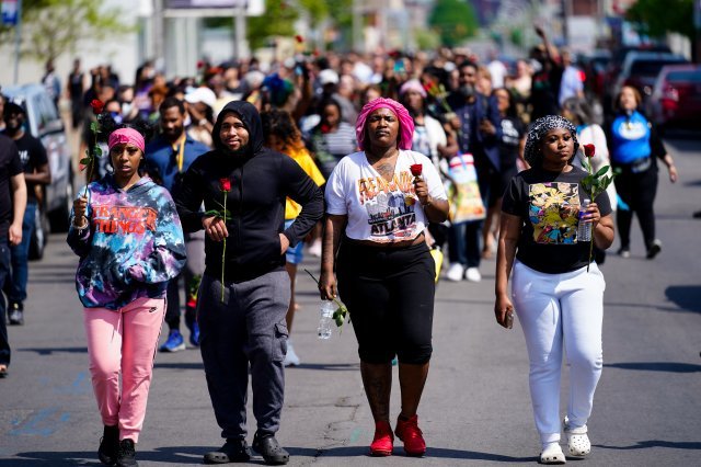 15일 총기 난사 사건이 발생한 톱스프렌들리 마켓 인근에 장미꽃을 든 시민들이 모여 사망자들을 추모하고 인종 차별에 반대하기 위해 행진하고 있다. 버팔로=AP 뉴시스