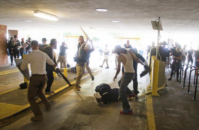 2017년 8월 미국 버지니아주 샬러츠빌 경찰서 주차장에서 한 아프리카계 미국인(가운데)이 백인 우월주의자들에게 둘러 쌓여 맞고 있다. 이날 샬러츠빌 일대에서는 백인 우월주의를 내세우는 유혈 시위가 발생했다. 샬러츠빌=AP 뉴시스