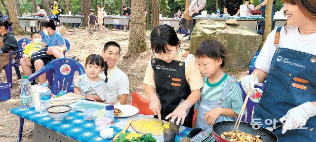 28일 충남 서산 용현자연휴양림에서 열린 숲속 요리교실 ‘포레스토랑’에 참가한 가족들이 요리강사로부터 임산물 요리를 배우며 직접 요리하고 있다. 이기진 기자 doyoce@donga.com