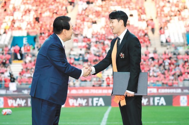 윤석열 대통령(왼쪽)이 2일 서울월드컵경기장에서 한국과 브라질 축구대표팀의 A매치가 열리기에 앞서 손흥민에게 체육훈장 청룡장을 수여한 뒤 악수하고 있다. 대통령실사진기자단