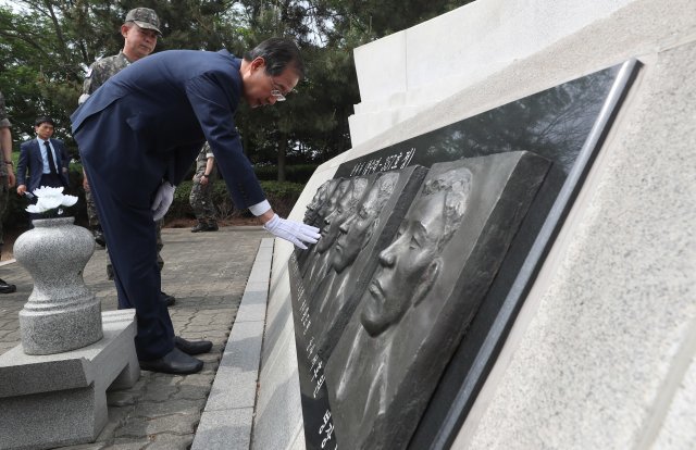 한덕수 국무총리가  경기 평택시 해군 2함대사령부에서 제2연평해전 전적비를 참배한 후 전사자 부조상을 어루만지고 있다. 뉴시스