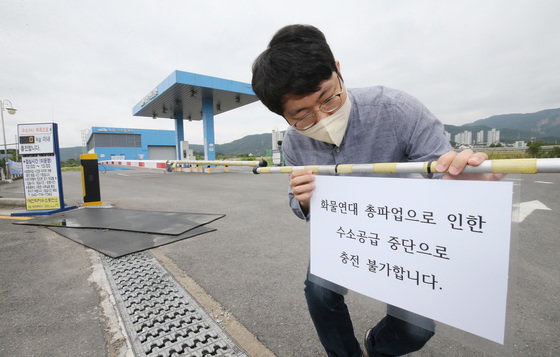 화물연대 총파업이 이틀째 이어지고 있는 가운데 8일 대전 유성구 학하수소충전소에서 관계자가 운영중단 안내문을 붙이고 있다. 대전에 위치한 수소충전소는 총 3곳으로 8일 학하충전소부터 시작돼 9일 낭월충전소, 10일 신대충전소가 운영이 중단된다. 2022.6.8/뉴스1
