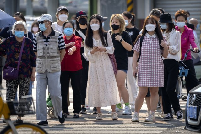 8일 중국 베이징에서 마스크를 쓴 출근길 시민들이 교차로에서 신호를 기다리고 있다. 코로나19 확산세가 이어지는 단둥시는 북한에서의 유입을 우려해 남풍이 부는 날에는 창문을 닫으라는 지침을 내린 것으로 알려졌다. 2022.06.08. 베이징=AP/뉴시스
