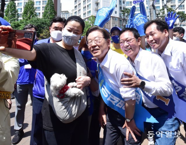 제8회 전국 동시지방선거(국회의원 보궐선거)가 하루 앞으로 다가온 31일 인천 남동구 호구포로 모래내시장을 찾은 이재명 더불어민주당 총괄선대위원장(계양을 국회의원후보, 오른쪽 세 번째), 박남춘 인천시장 후보(오른쪽 두 번째) 등 지방선거 후보자들이 한 시민과 셀카를 찍고 있다.사진공동취재단.