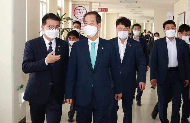 한덕수 국무총리가 9일 세종시 정부세종청사 교육부를 방문, 장상윤 차관과 이야기를 나누며 인재양성정책과로 이동하고 있다. 교육부 제공