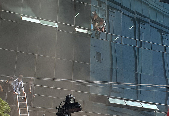 9일 오전 10시55분쯤 대구 수성구 범어동 대구지방법원 인근 7층짜리 빌딩 2층에서 방화로 인한 불이 나 7명이 숨지고 40여명이 다치는 등 다수의 인명피해가 발생했다. 화재 직후 건물 내부에 갇혀있던 시민들이 깨진 유리창을 통해 구조를 요청하고 있고 일부는 사다리를 이용해 탈출하고 있다. (독자 제공) 2022.6.9/뉴스1 © News1 공정식 기자