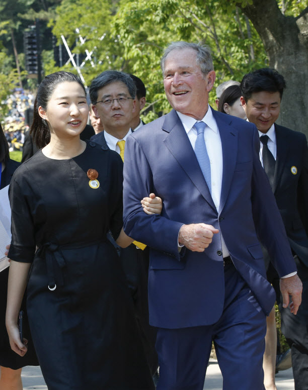 고(故) 노무현 전 대통령 10주기 추모식에서 조지 W. 부시 전 미국 대통령이 묘역 참배를 마치고 노 전 대통령의 손녀 노서은양과 팔짱을 낀 채 이동하고 있다. (노무현재단 제공) © 뉴스1