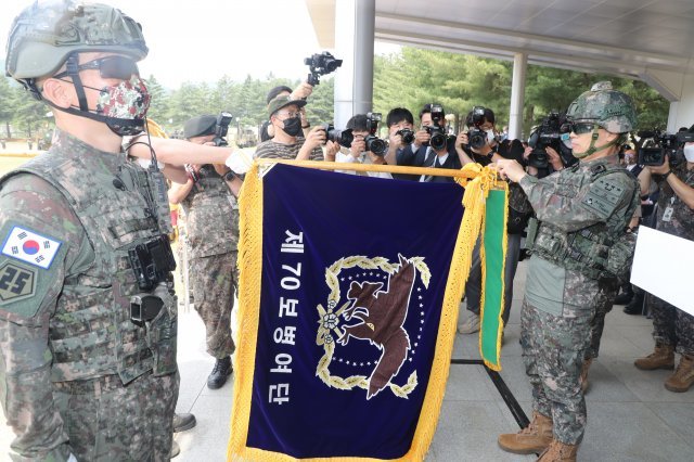 워리어플랫폼 을 착용한 박정환 육군참모총장(오른쪽)이 제70보병여단기에 아미타이거 시범여단 전투단 부대수치를 달아 주고 있다.