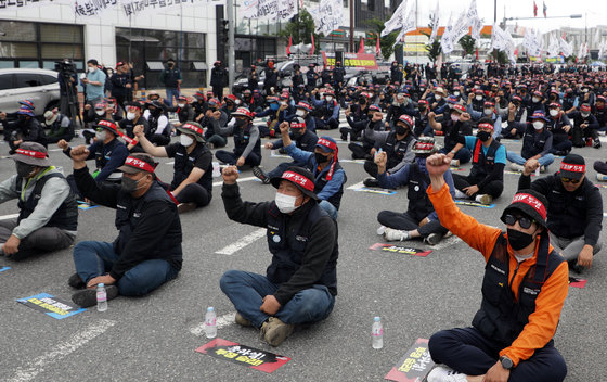 민주노총 전국공공운수노동조합 화물연대 울산본부 조합원들이 7일 오전 울산 남구 울산신항 앞에서 가진 총파업 출정식에서 구호를 외치고 있다. 화물연대는 Δ안전운임 일몰제 폐지 Δ안전운임 전차종·전품목 확대 Δ운송료 인상 Δ지입제 폐지 Δ노동기본권 확대 및 산재보험 확대 등 5가지를 정부에 요구하고 있다. 2022.6.7/뉴스1