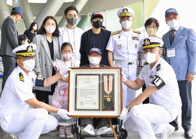 10일 오전 충남 계룡시 계룡대 대연병장에서 열린 6·25전쟁 참전용사 무공훈장 서훈식에서 행사에 참가한 유일한 생존 참전장병인 김무환 상사(1열 가운데)가 무공훈장을 받은 후 기념촬영을 하고 있다. 해군 제공