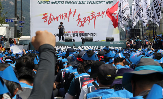 민주노총 서비스연맹 전국택배노동조합원들이 13일 오전 서울 세종대로 광화문사거리 일대에서 열린 ‘임금삭감, 쉬운 해고 노예계약 저지’ 우체국 택배노동자 총력 결의대회에서 구호를 외치고 있다. 2022.6.13/뉴스1