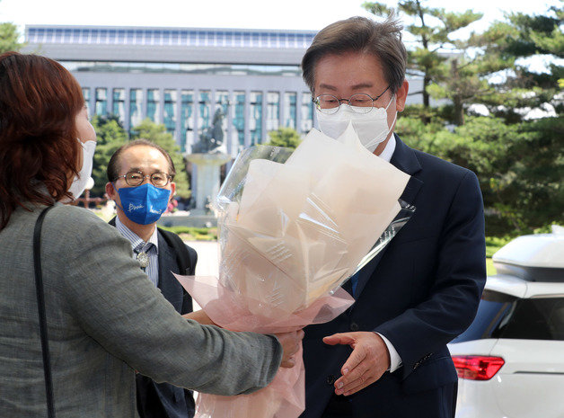 이재명 더불어민주당 의원이 7일 오전 서울 여의도 국회의원회관에 도착해 지지자로부터 꽃다발을 받고 있다. 사진공동취재단