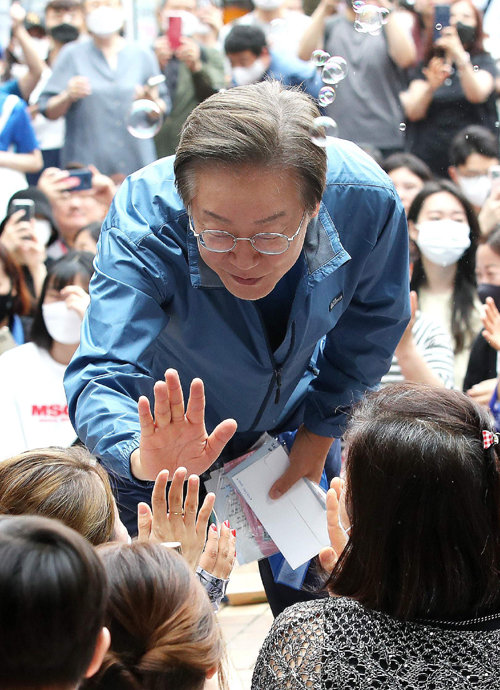 더불어민주당 이재명 의원이 18일 인천 계양구 계양산 야외공연장 앞에서 지지자들과 하이파이브를 하고 있다. 인천=뉴스1