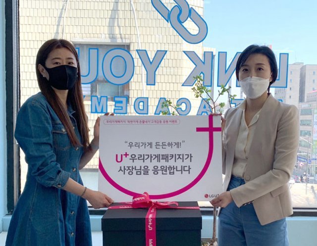 서울 서대문의 ‘링큐’사장님(왼쪽)이 LG유플러스 관계자와 U+우리가게패키지 선물을 들어 보이고 있다.