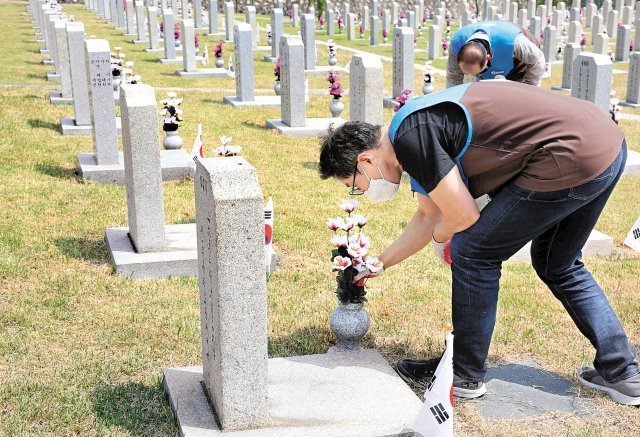 현충원 봉사활동에 참여한 GS리테일 임원이 묘비 정비를 하고 있다. GS리테일 제공